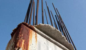 O que diz a norma? 9 a imagem tem um pilar com barras de espera (armadura de arranque) com sinais de corrosão.